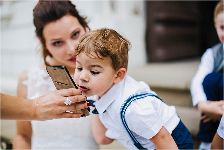 kind mit handy neben mutter braut